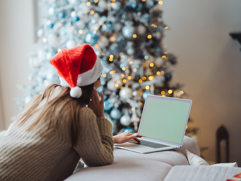 kobieta przegląda laptopa przy choince