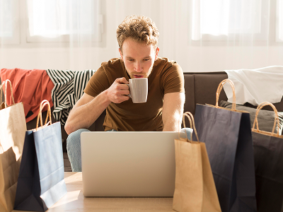 Mężczyzna pije napój przed komputerem