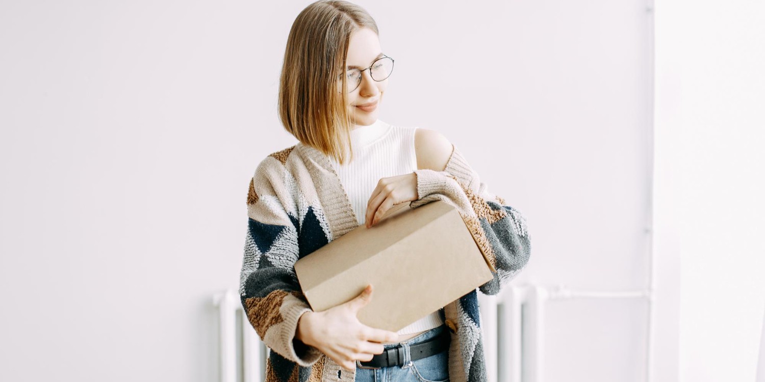 Kobieta w okularach trzymająca dużą paczkę